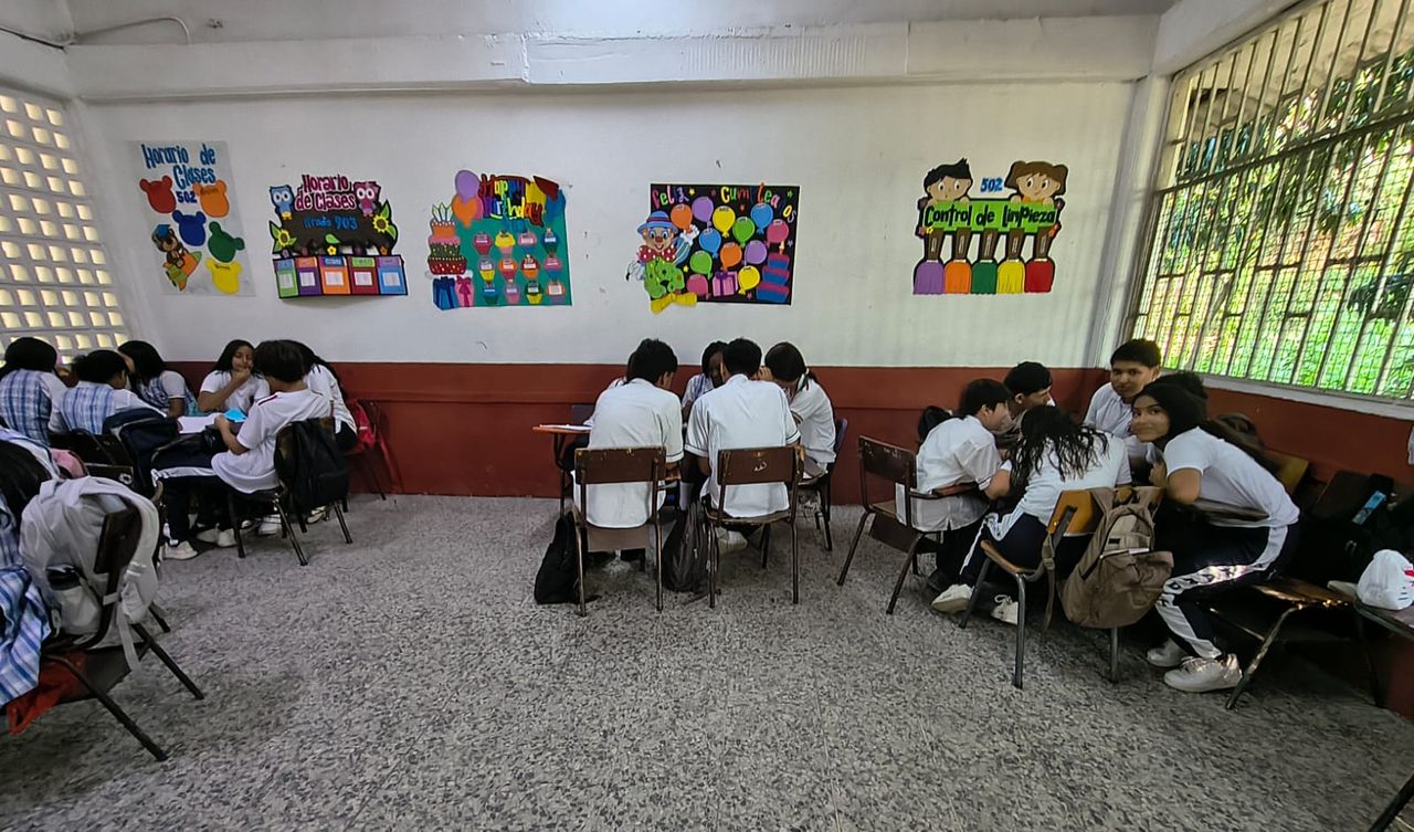 Equipos de estudiantes en mesas de trabajo